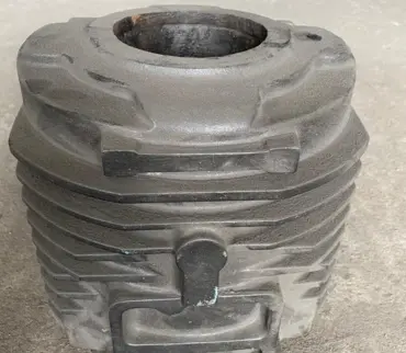 A metal cylindrical tank with a hollow opening in the middle, positioned on the floor of the manufactory plant