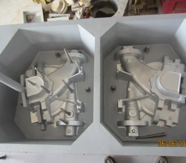 Two metal castings in a metal enclosure produced at a heavy industry and automotive parts manufacturing facility