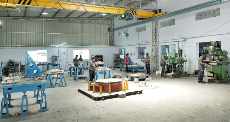 A large work area on a factory floor where employees are using machinery to create, assemble, and test precise patterns.